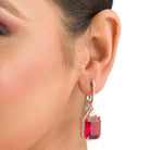 "Dark red zircon dangler earrings in rose gold offer a bold, sophisticated touch for party wear."
