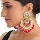 "Red kundan dangler earrings in gold add a vibrant touch to your festive look. Perfect for celebrations."
