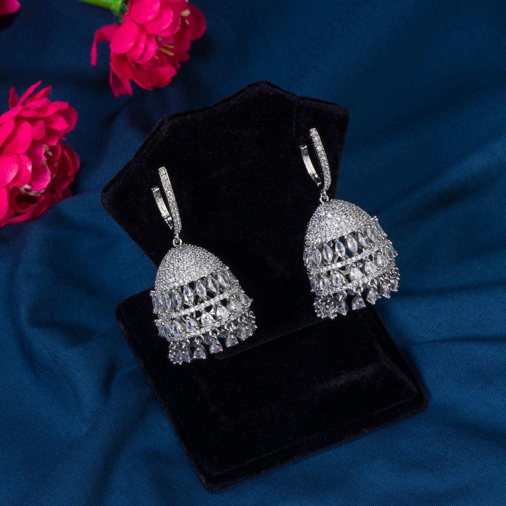 "Zircon jhumka earrings in silver combine intricate detailing with radiant sparkle for a stunning, traditional party wear touch."
