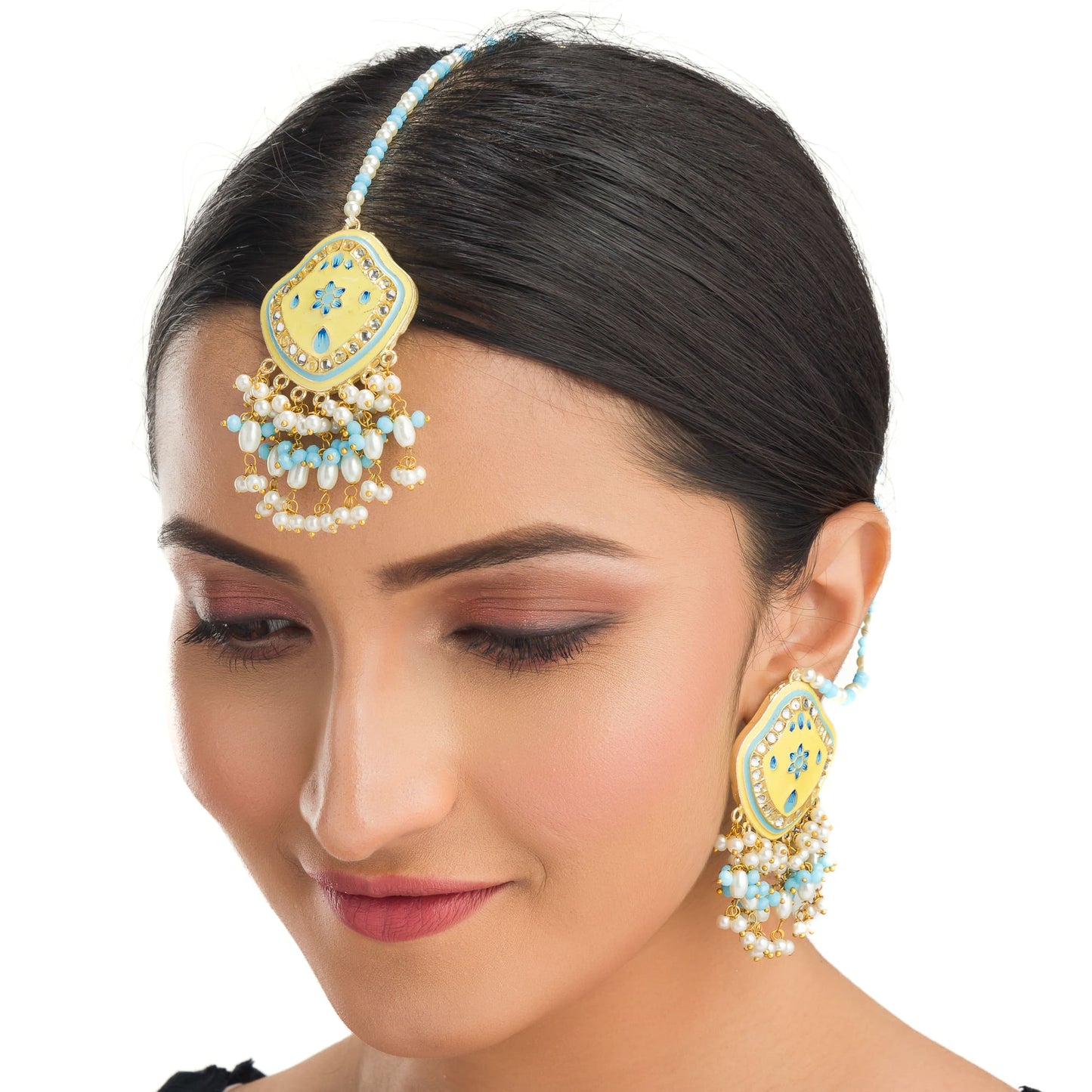 "WHEAT-COLORED EARRINGS AND MAANGTIKA, ADORNED WITH AQUA AND WHITE PEARL BEADS, OFFER A GRACEFUL BLEND OF SUBTLE ELEGANCE AND VIBRANT CHARM."