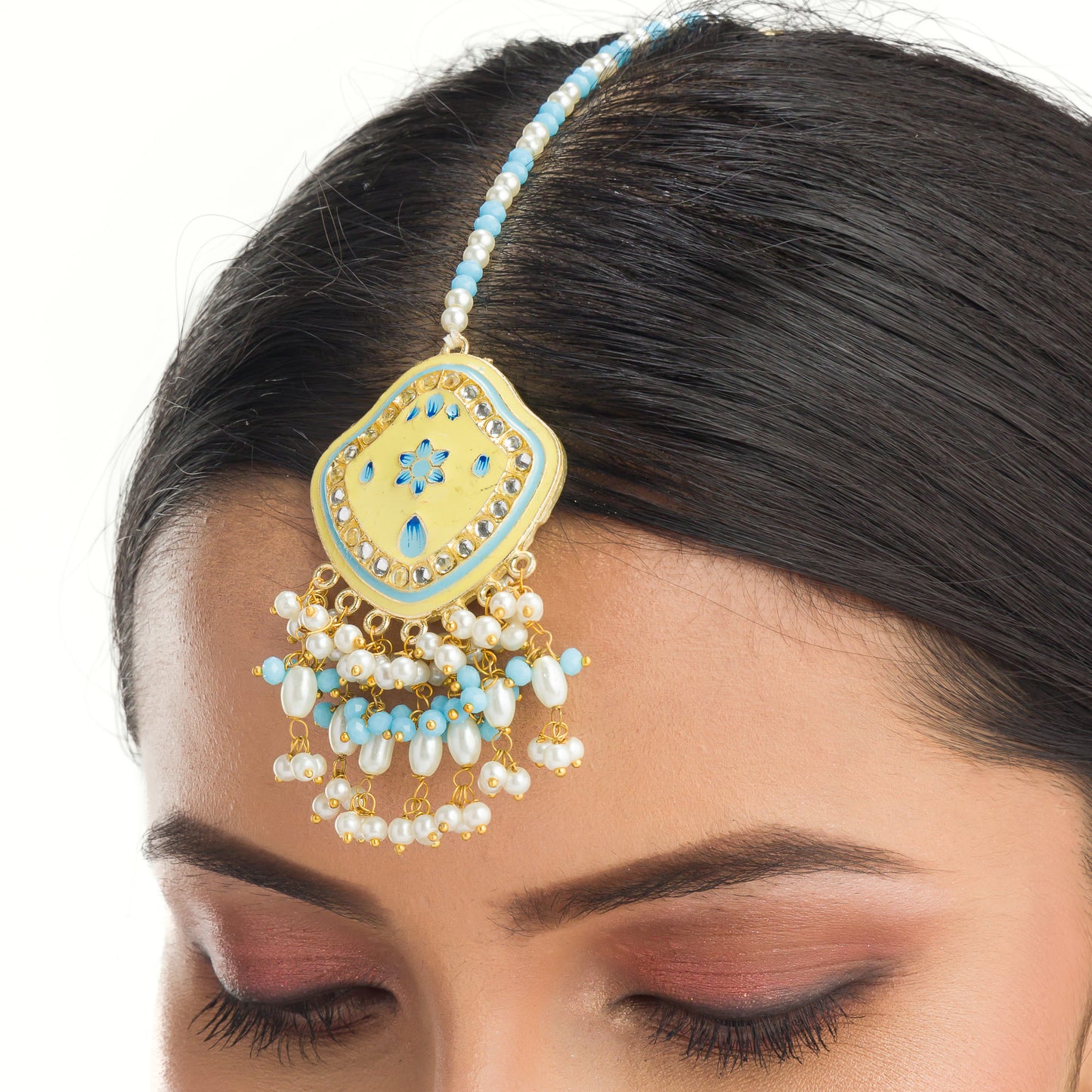 "WHEAT-COLORED EARRINGS AND MAANGTIKA, ADORNED WITH AQUA AND WHITE PEARL BEADS, OFFER A GRACEFUL BLEND OF SUBTLE ELEGANCE AND VIBRANT CHARM."