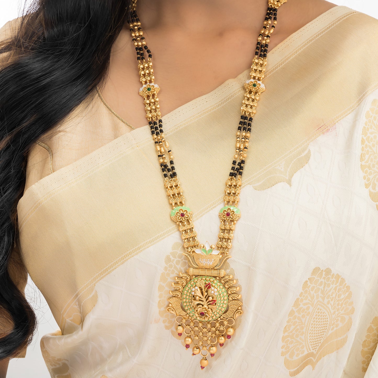 FLORAL DESIGN STUDDED GOLD-TONE MANGALSUTRA WITH BLACK BEADS AND MATCHING EARRINGS.