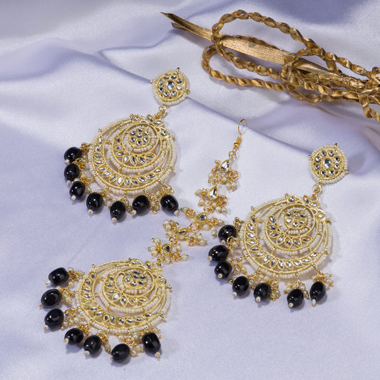 "BLACK KUNDAN SET IN GOLD POLISH, PAIRED WITH A MATCHING MAANGTIKA, EXUDES REGAL SOPHISTICATION AND TIMELESS ELEGANCE."