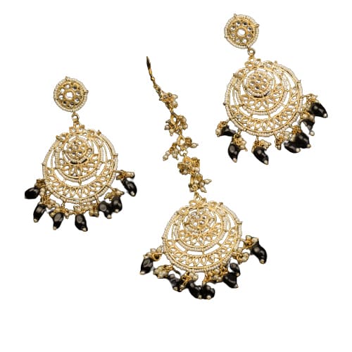 "BLACK KUNDAN SET IN GOLD POLISH, PAIRED WITH A MATCHING MAANGTIKA, EXUDES REGAL SOPHISTICATION AND TIMELESS ELEGANCE."