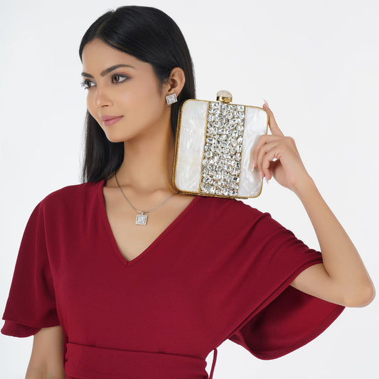 SHINE WITH ELEGANCE IN THIS MOTHER OF PEARL CLUTCH, STUDDED WITH ZIRCON STONES AND COMPLEMENTED BY A CHIC SLING CHAIN.