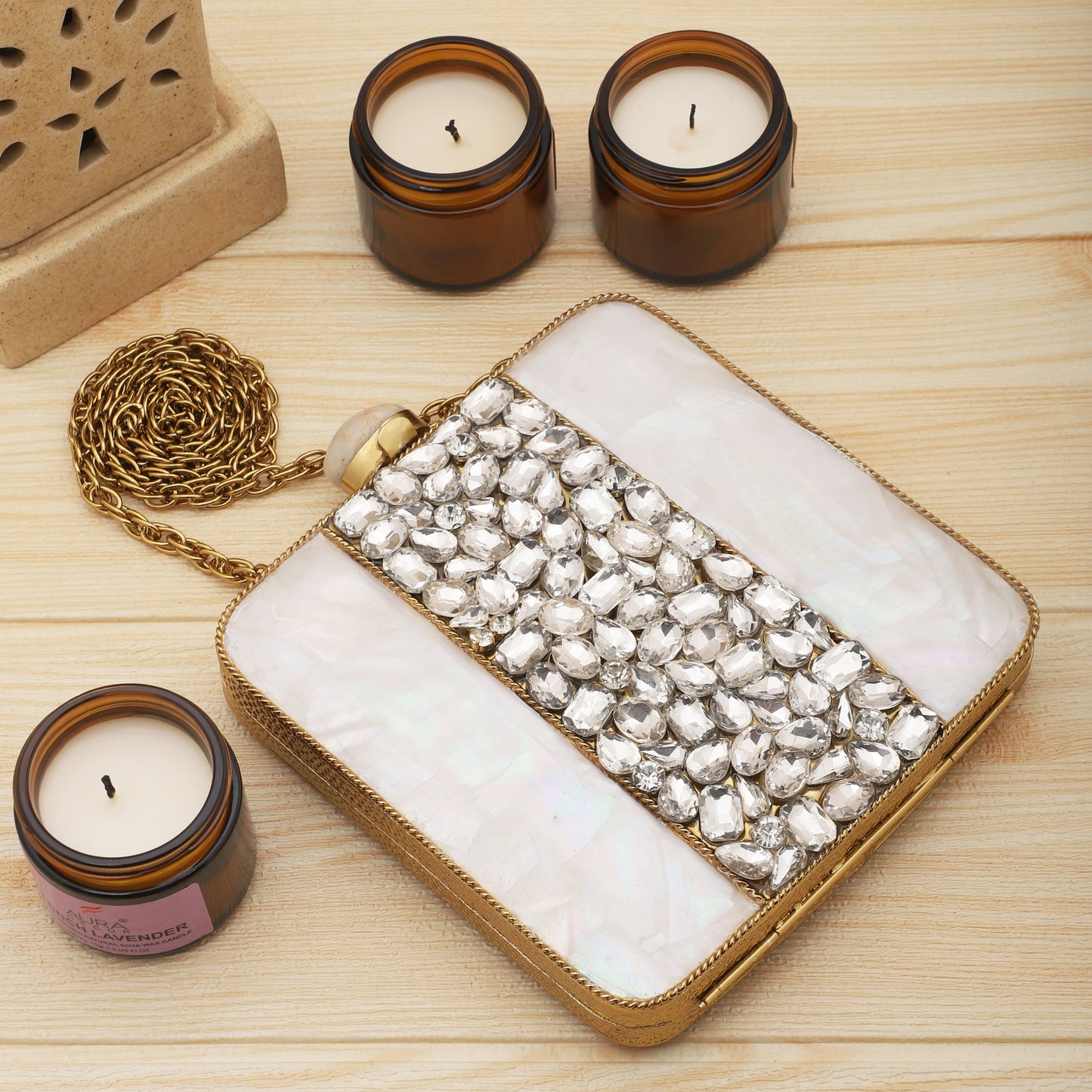 SHINE WITH ELEGANCE IN THIS MOTHER OF PEARL CLUTCH, STUDDED WITH ZIRCON STONES AND COMPLEMENTED BY A CHIC SLING CHAIN.