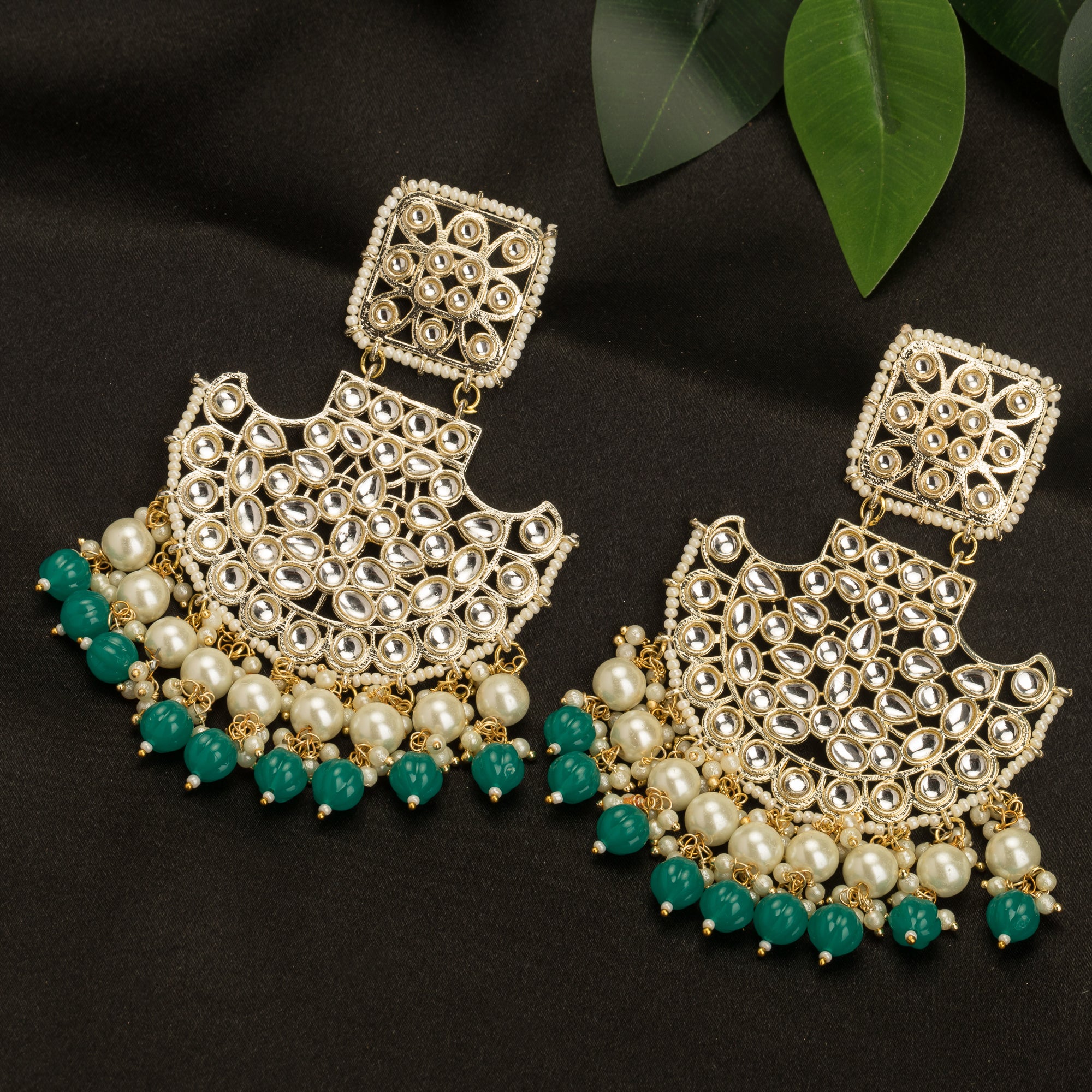 1. "Kundan channbali earrings with green and white pearls offer a regal, timeless allure."
