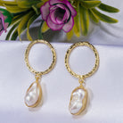 "Golden earrings with white uncut stones blend classic elegance with modern flair."
