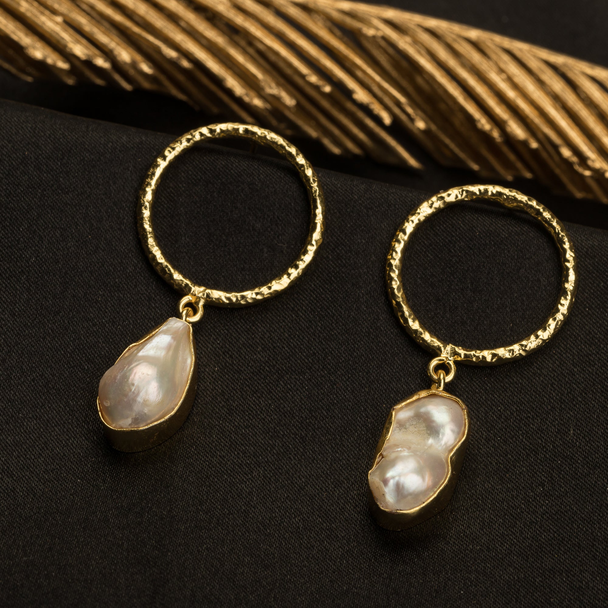 "Golden earrings with white uncut stones blend classic elegance with modern flair."
