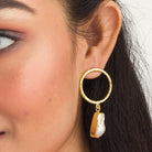 "Golden earrings with white uncut stones blend classic elegance with modern flair."
