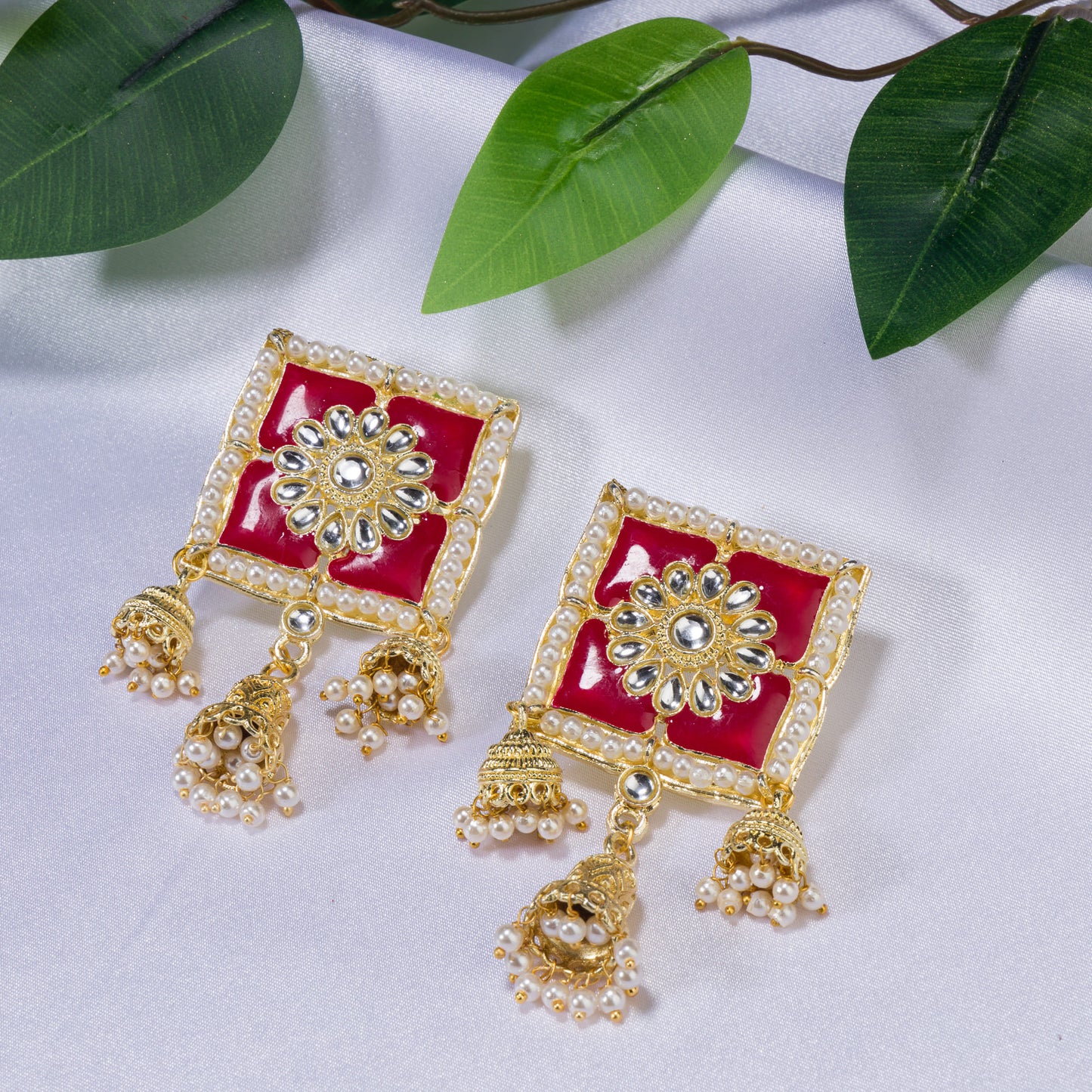 "RED SQUARE GOLD JHUMKA BLENDS BOLD COLOR WITH CLASSIC ELEGANCE FOR A STRIKING LOOK."