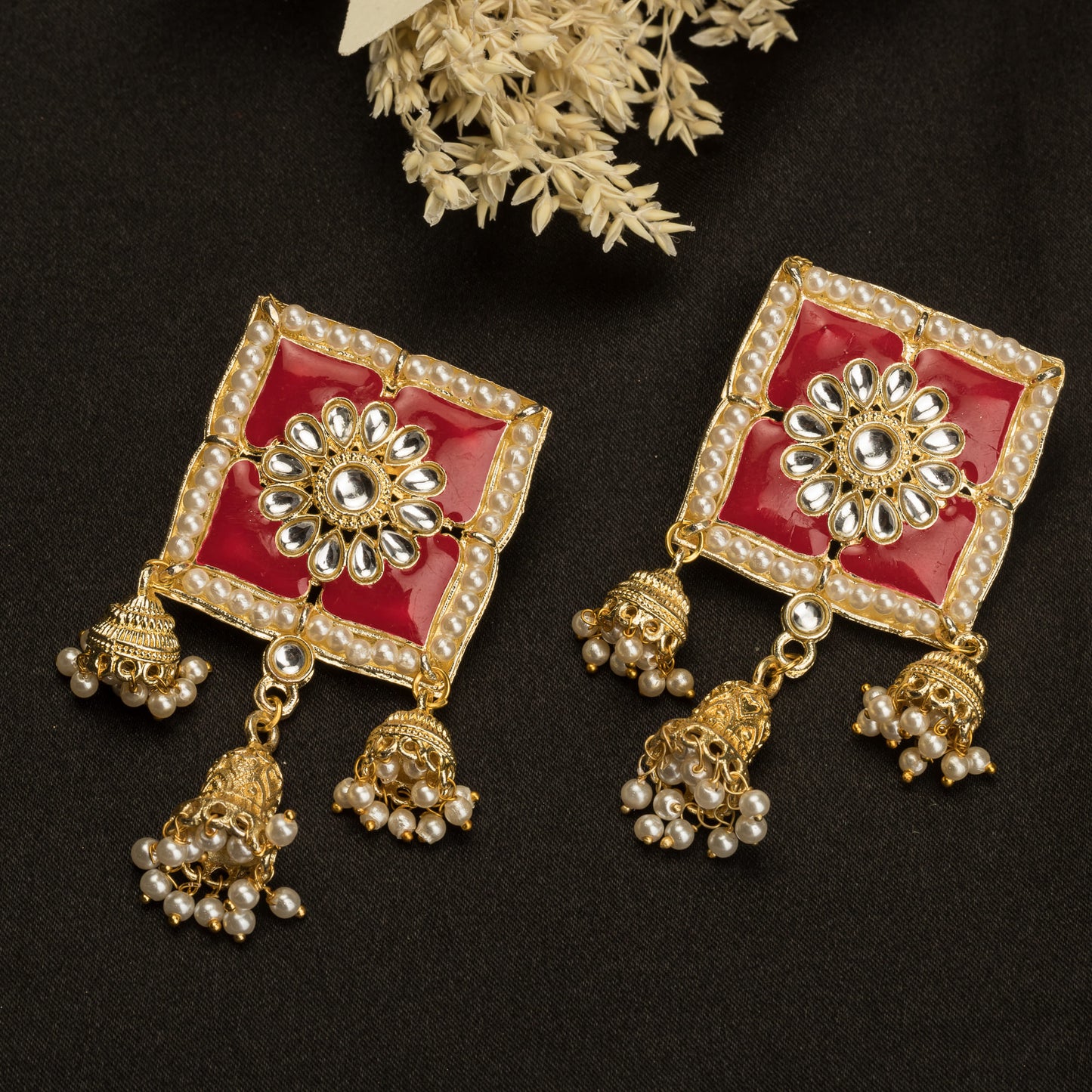 "RED SQUARE GOLD JHUMKA BLENDS BOLD COLOR WITH CLASSIC ELEGANCE FOR A STRIKING LOOK."