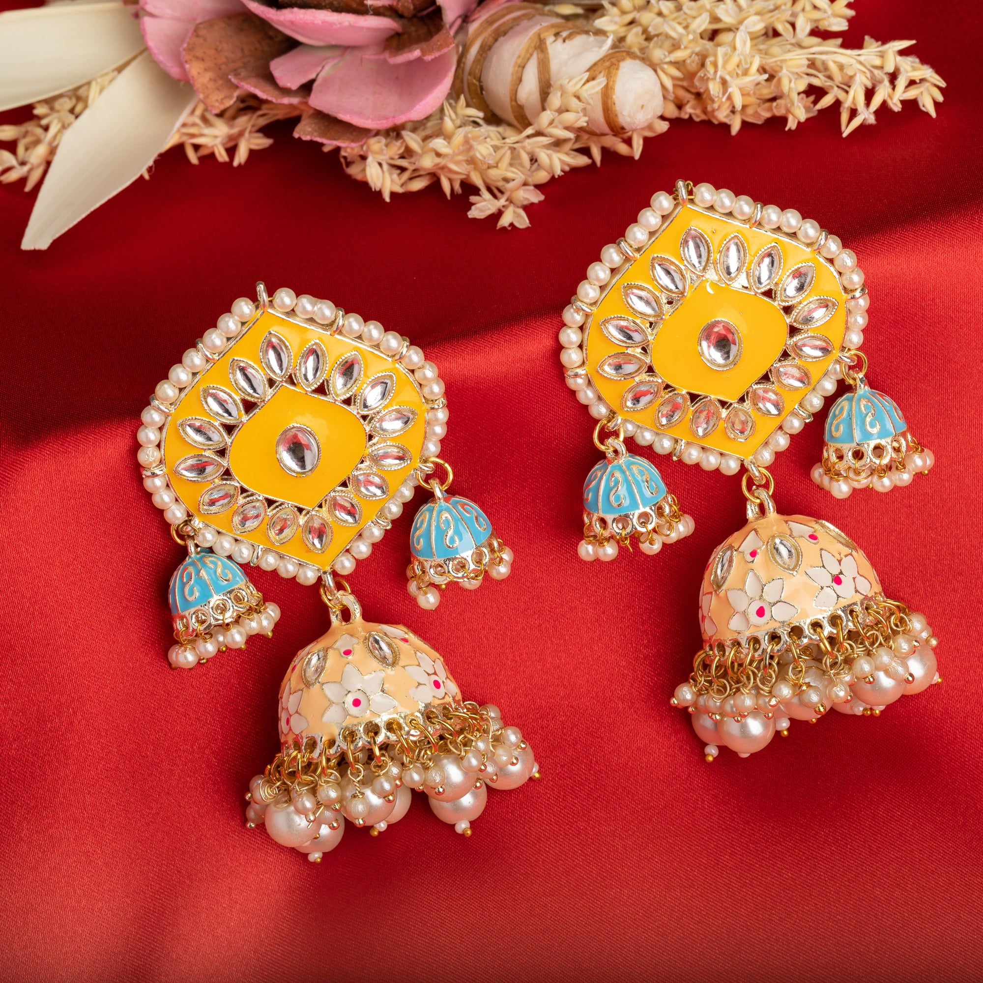 "Yellow and blue gold jhumka earrings blend bold colors with classic elegance for a striking look."
