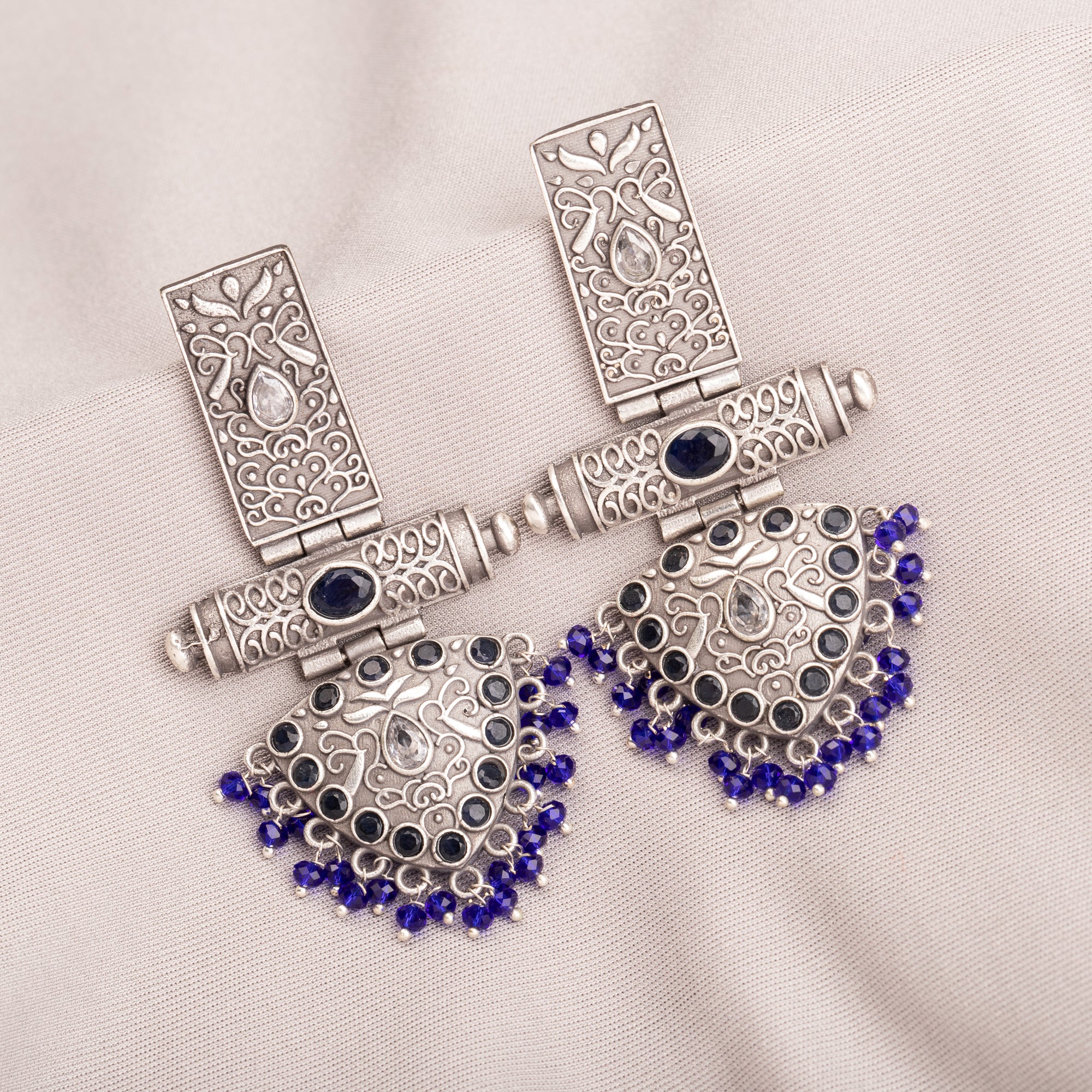 "Oxidized earrings with blue beads offer a unique vintage touch and a pop of color."
