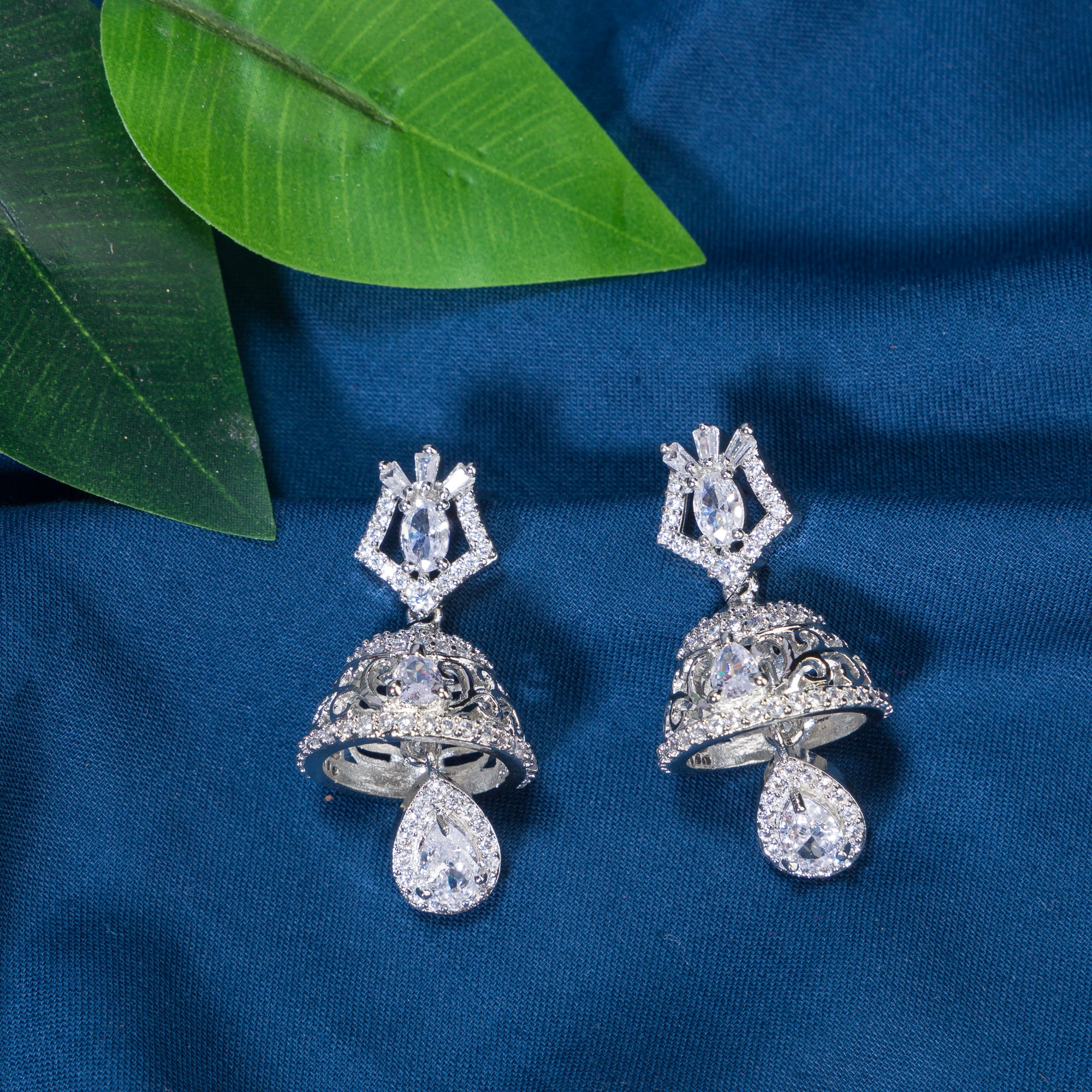 "Zircon jhumkas with intricate designs and sparkling stones create a dazzling statement."
