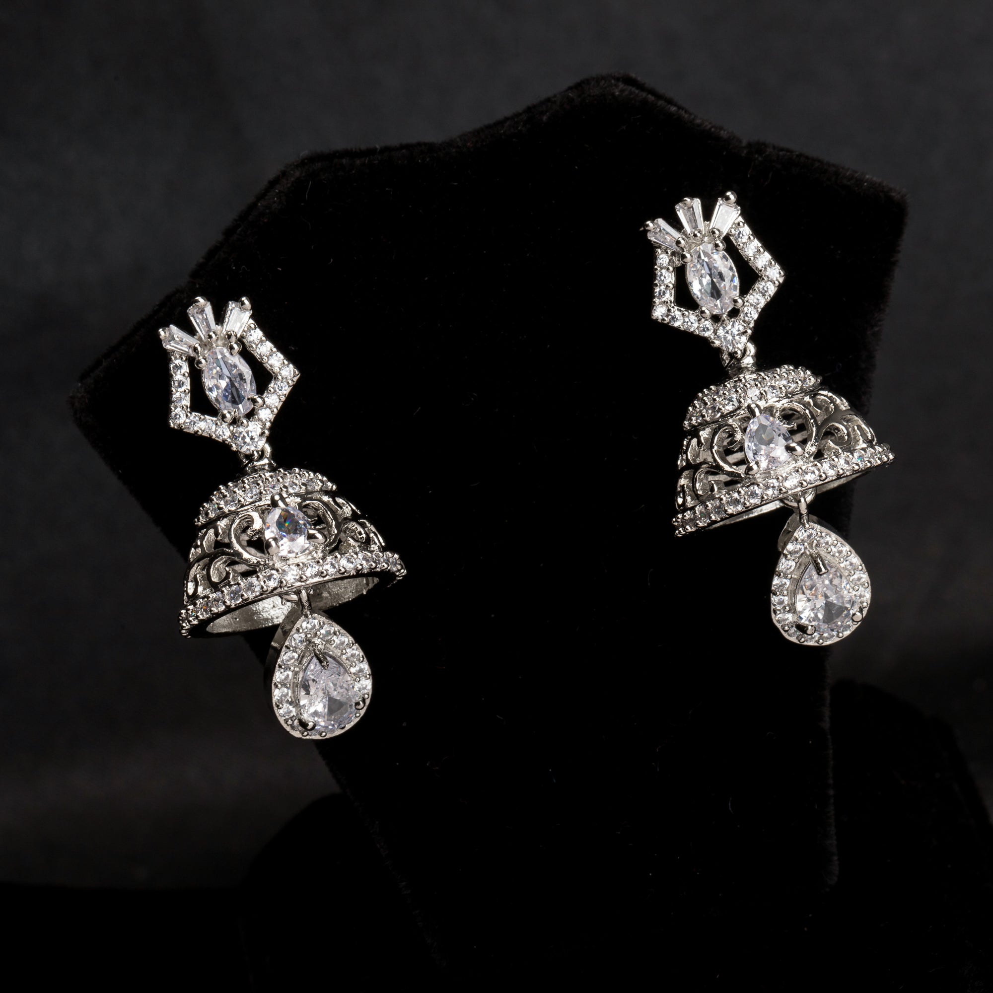 "Zircon jhumkas with intricate designs and sparkling stones create a dazzling statement."
