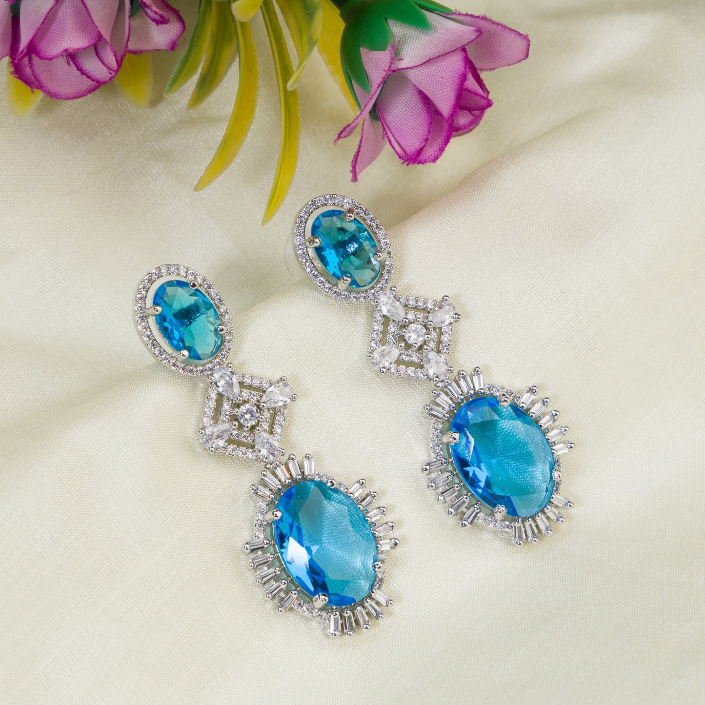 "BLUE ZIRCON DANGLER EARRINGS EXUDE A DEEP, CAPTIVATING SPARKLE."