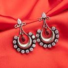 "Oxidized studs with red and white stones create a striking vintage-inspired contrast."
