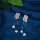 "Silver zircon earrings with hanging pearls offer elegant sparkle and sophistication."
