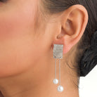 "Silver zircon earrings with hanging pearls offer elegant sparkle and sophistication."
