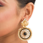 "Gold-tone earrings with black pearl add elegant warmth and striking contrast to any outfit."
