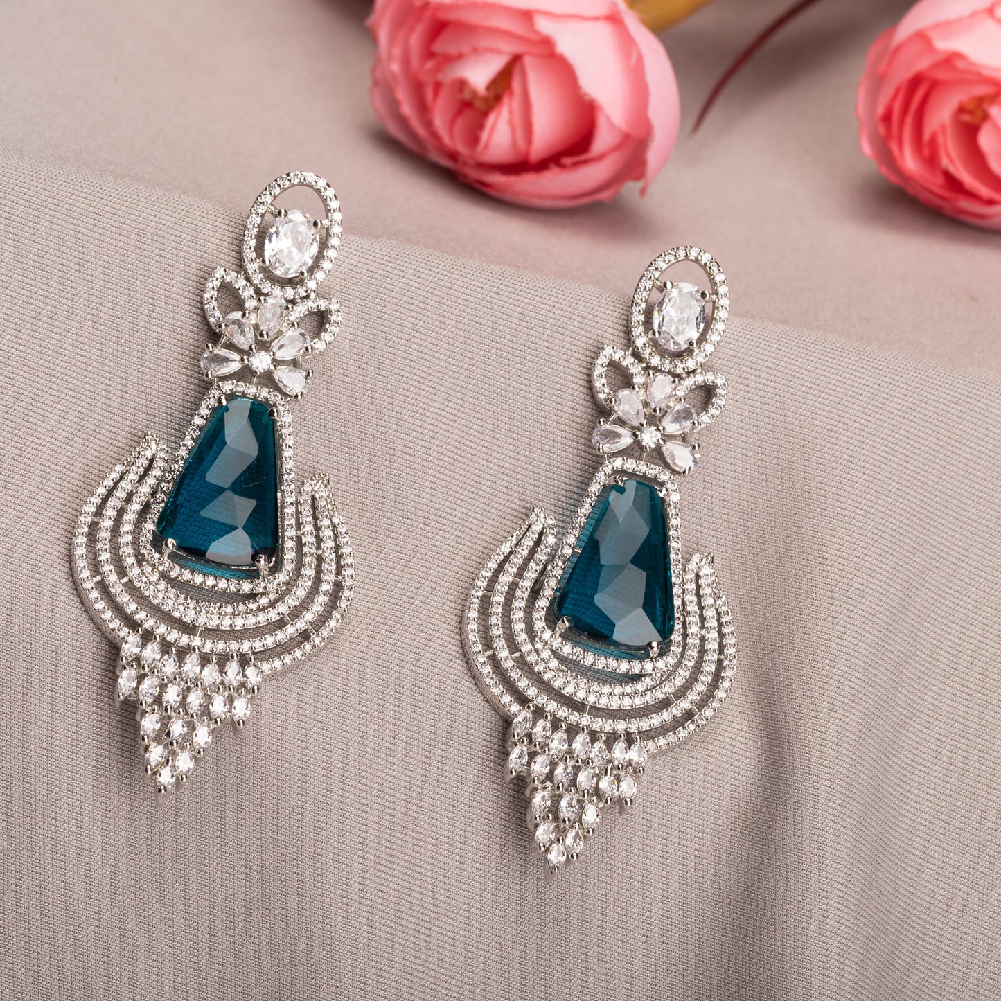 TEAL COLOURED ZIRCON STUDDED EARRINGS OFFER A STRIKING AND VIBRANT LOOK.