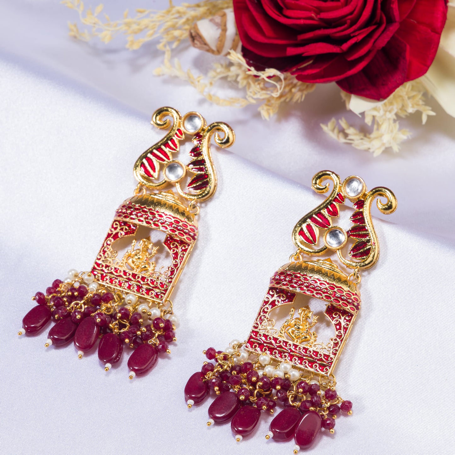 GOLDTONE EARRING  WITH EXQUISITE GANESH IDOL, CRAFTED DESIGNED WITH MAROON PEARL ACCENTS, ADDS A TOUCH OF CLASSIC CHARM TO ANY SPACE.