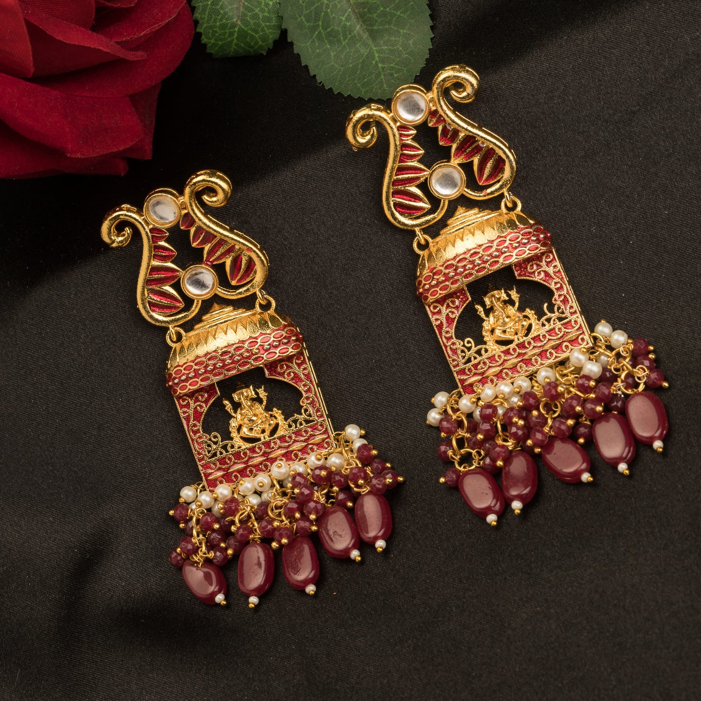 GOLDTONE EARRING  WITH EXQUISITE GANESH IDOL, CRAFTED DESIGNED WITH MAROON PEARL ACCENTS, ADDS A TOUCH OF CLASSIC CHARM TO ANY SPACE.