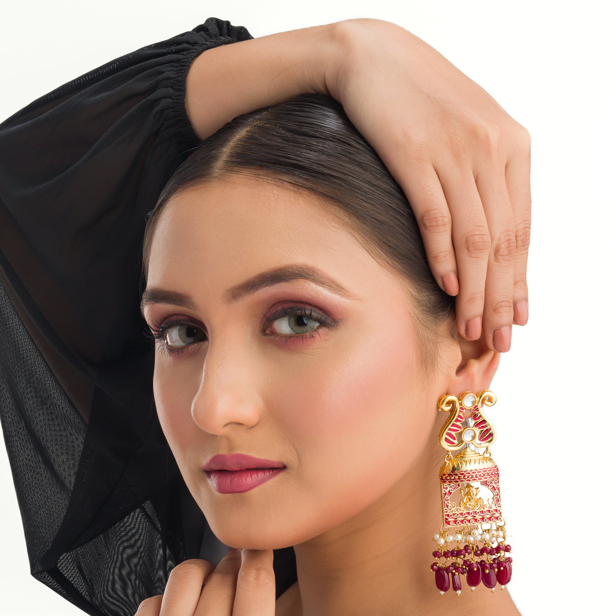 "Ganesh idol earrings with kundan and gold-tone polish add classic charm and grace."
