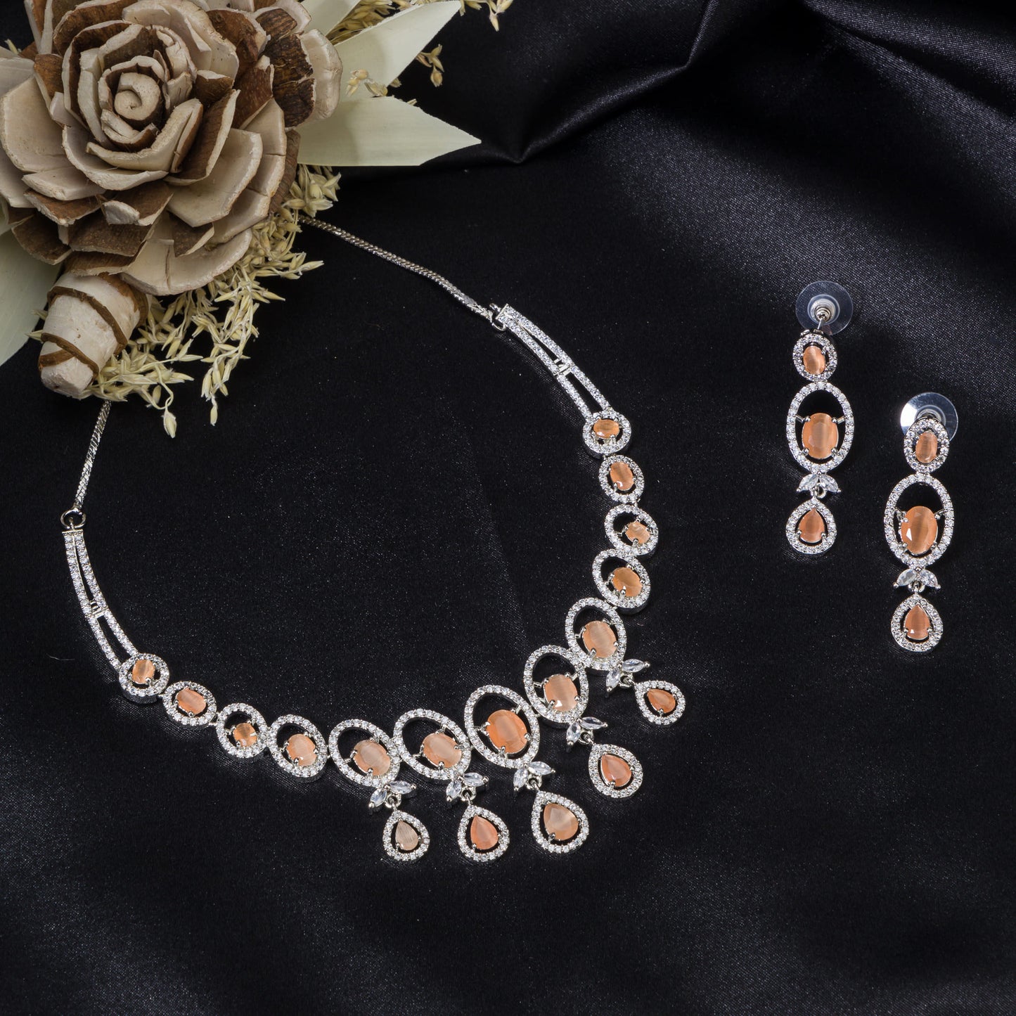 A ROUND SALMON ZIRCON NECKLACE WITH WHITE ZIRCONS ADDS VIBRANT SPARKLE.