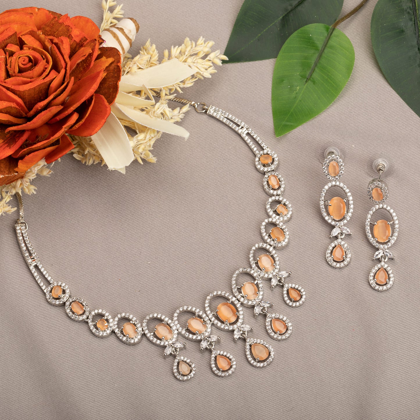 A ROUND SALMON ZIRCON NECKLACE WITH WHITE ZIRCONS ADDS VIBRANT SPARKLE.