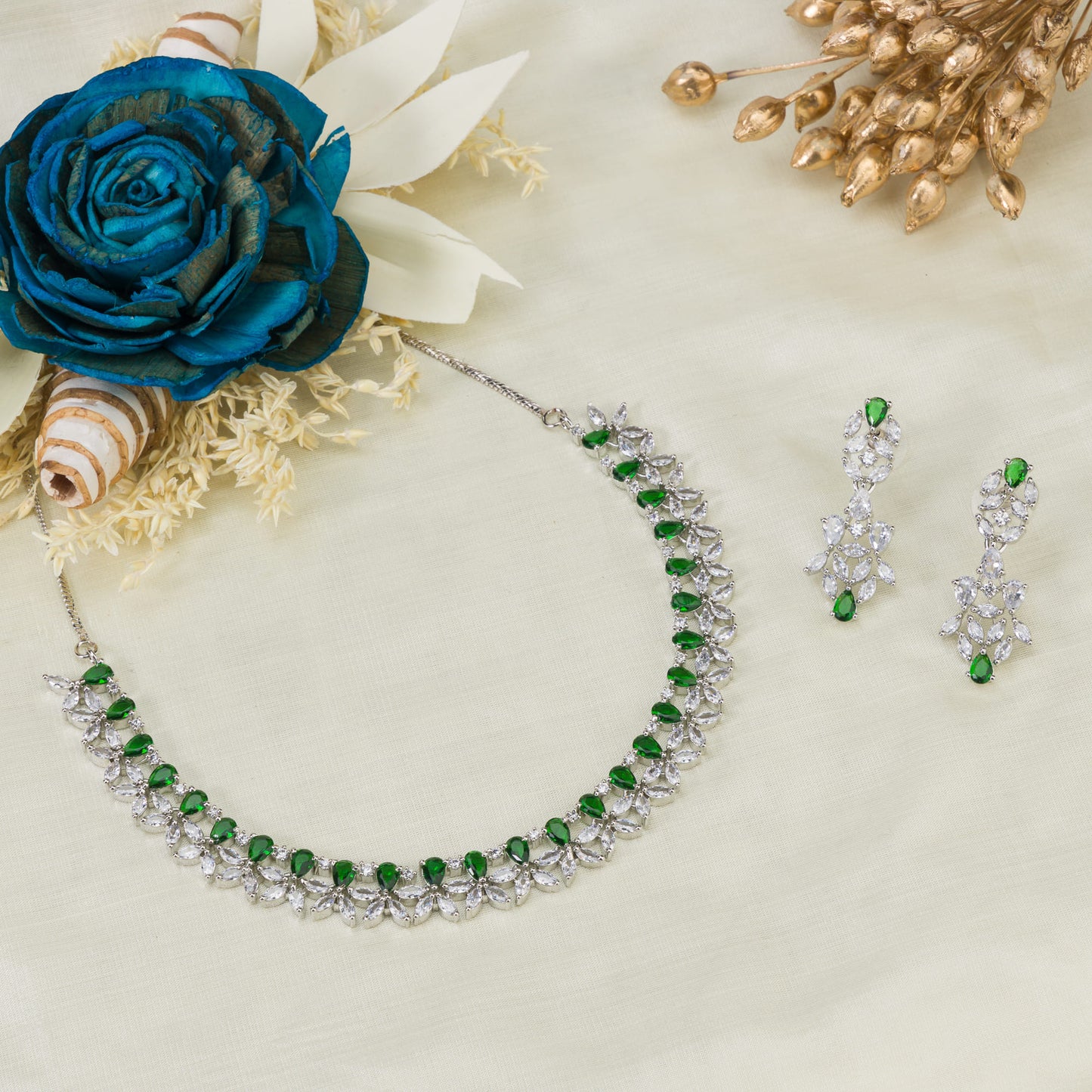 GREEN AND WHITE ZIRCONS IN A FLOWER DESIGN CREATE A VIBRANT, FLORAL ELEGANCE.