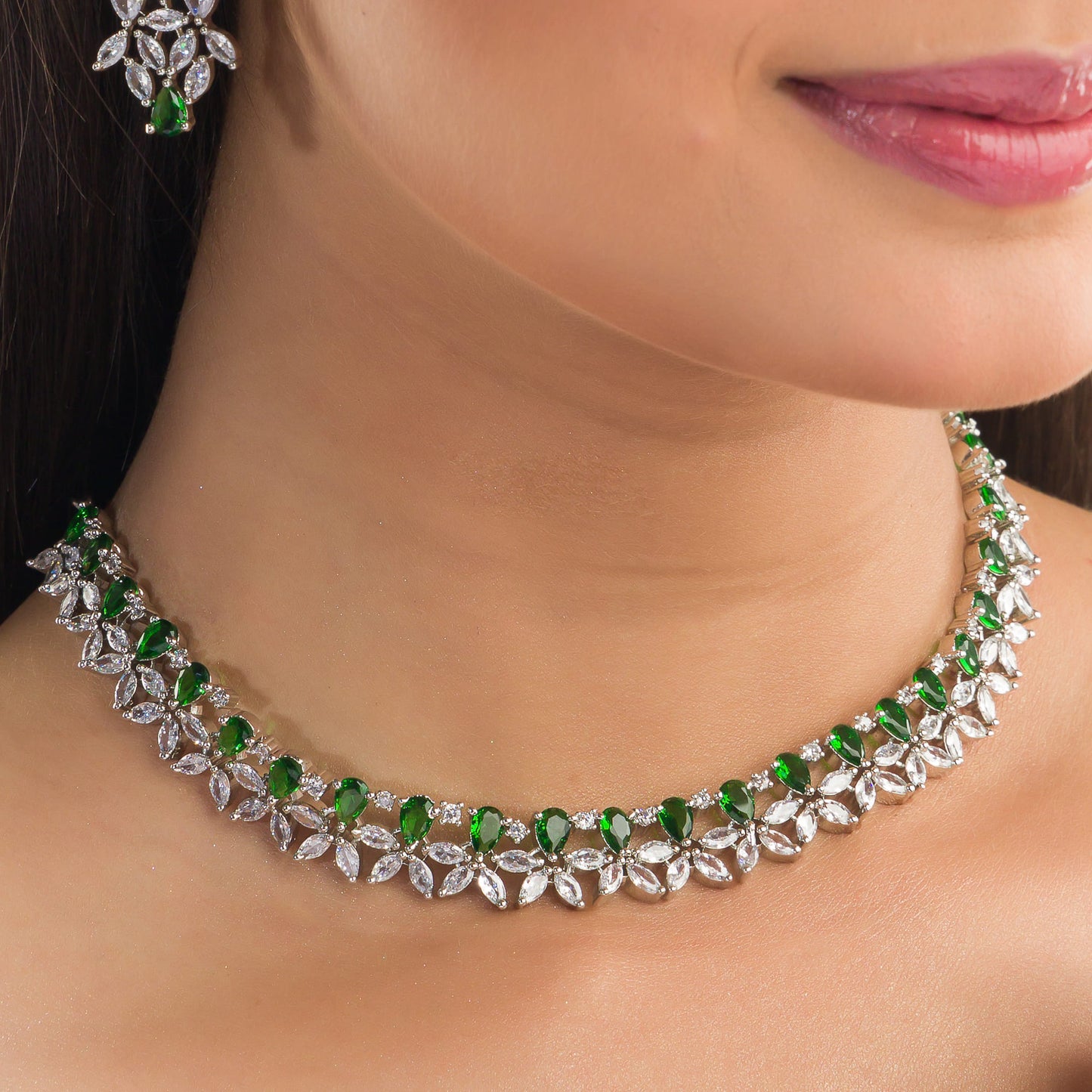 GREEN AND WHITE ZIRCONS IN A FLOWER DESIGN CREATE A VIBRANT, FLORAL ELEGANCE.