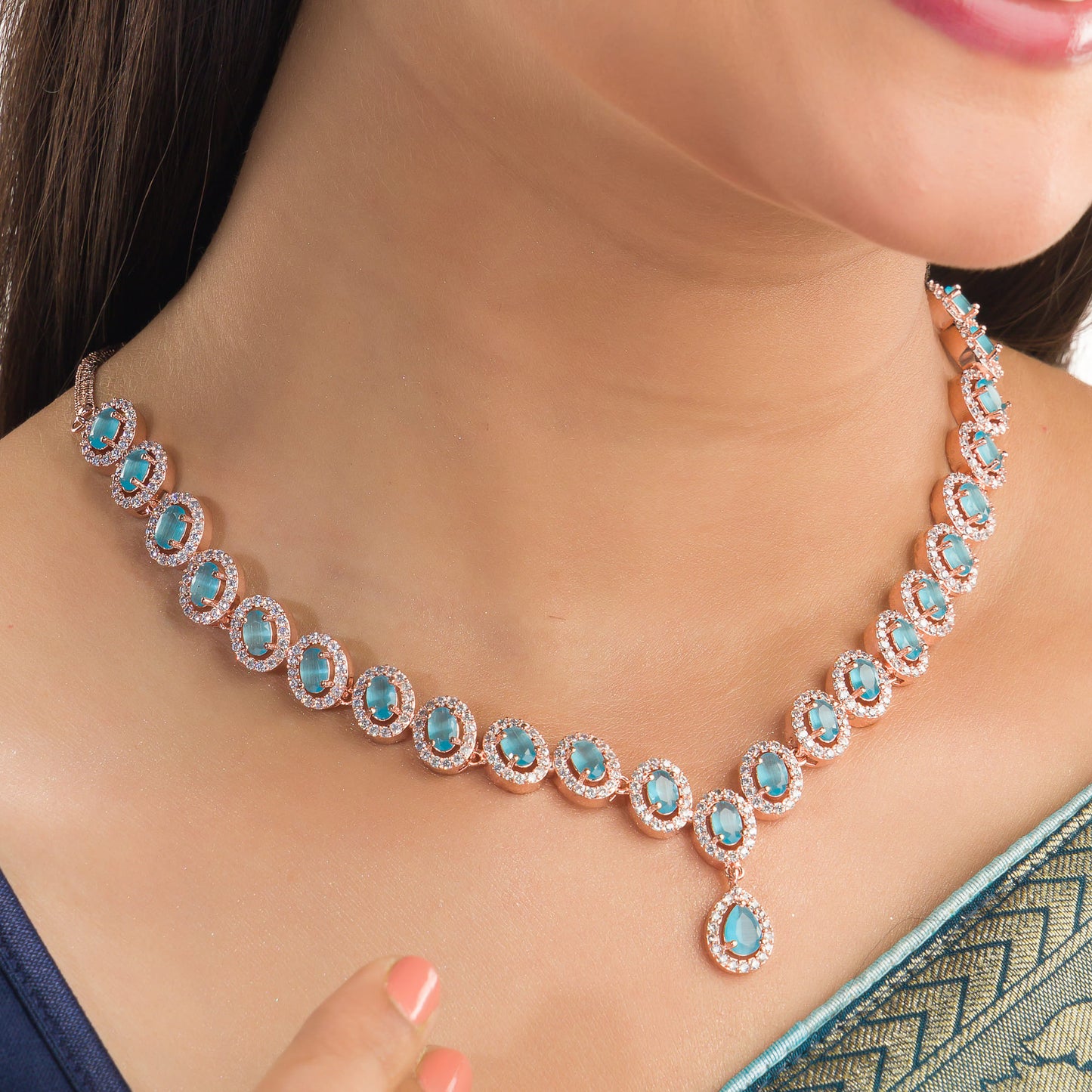 AN AQUA ZIRCON NECKLACE WITH ROSE GOLD POLISH RADIATES MODERN ELEGANCE.