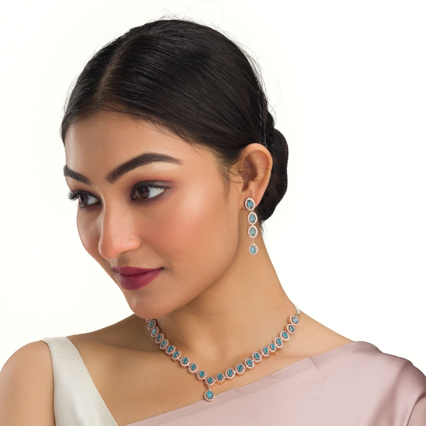 AN AQUA ZIRCON NECKLACE WITH ROSE GOLD POLISH RADIATES MODERN ELEGANCE.