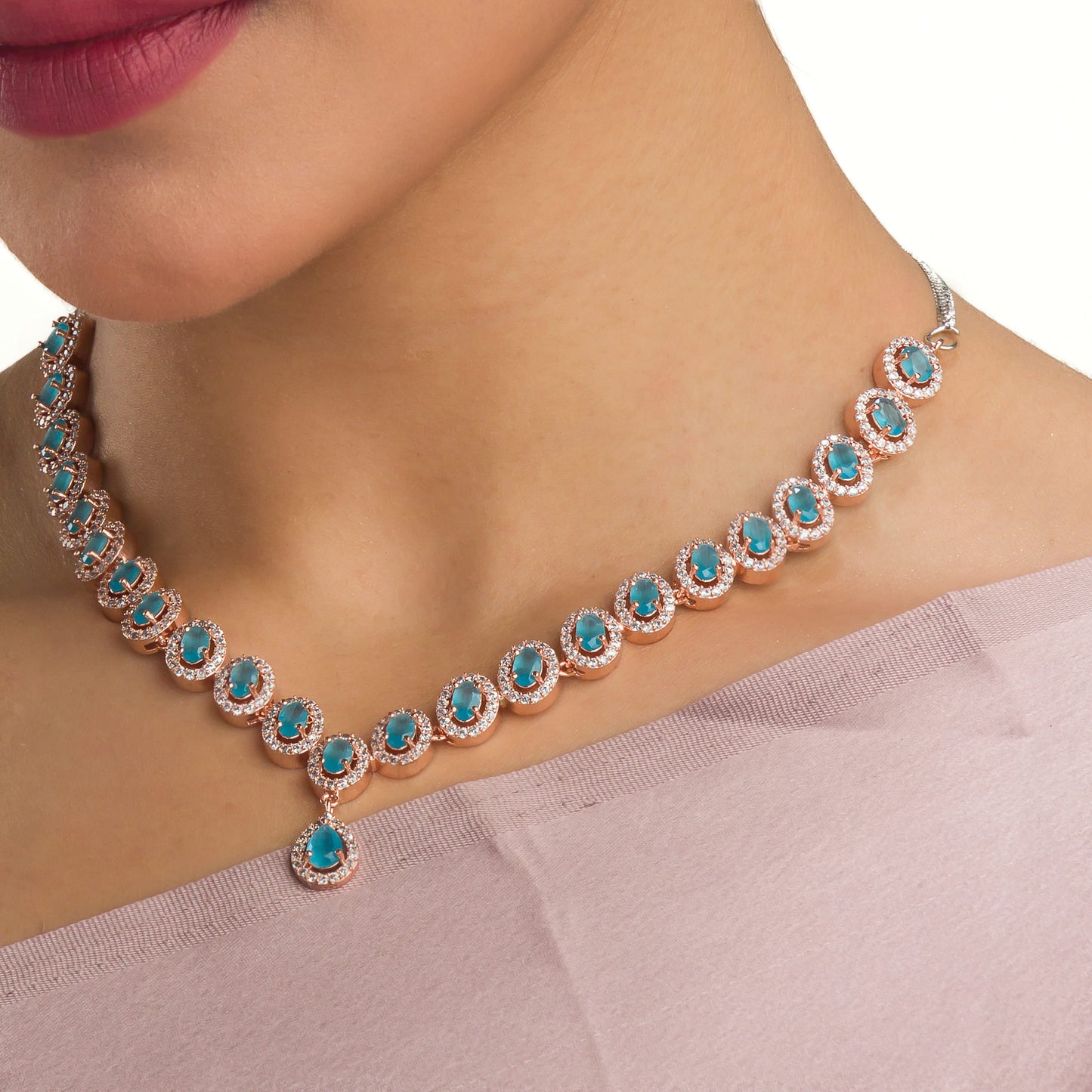 AN AQUA ZIRCON NECKLACE WITH ROSE GOLD POLISH RADIATES MODERN ELEGANCE.