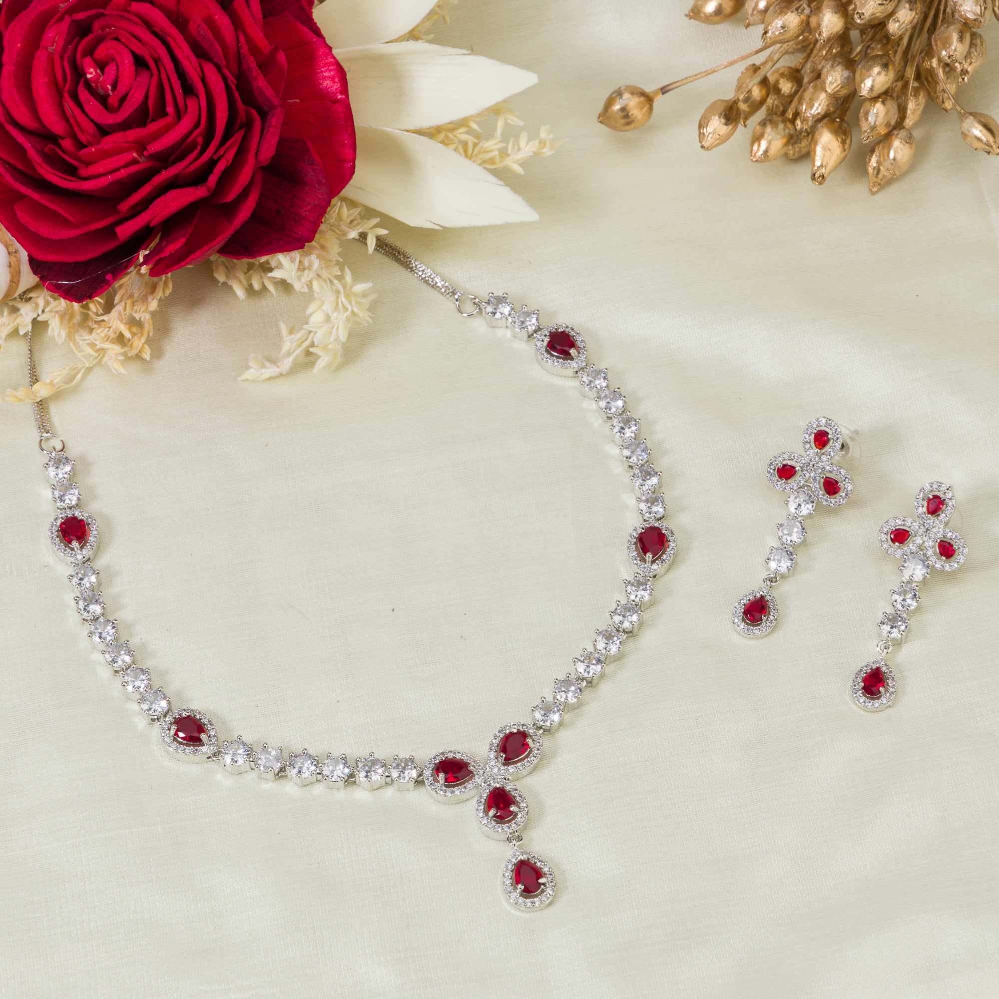 "Silver zircon necklace with maroon stone offers sophisticated, striking contrast."
