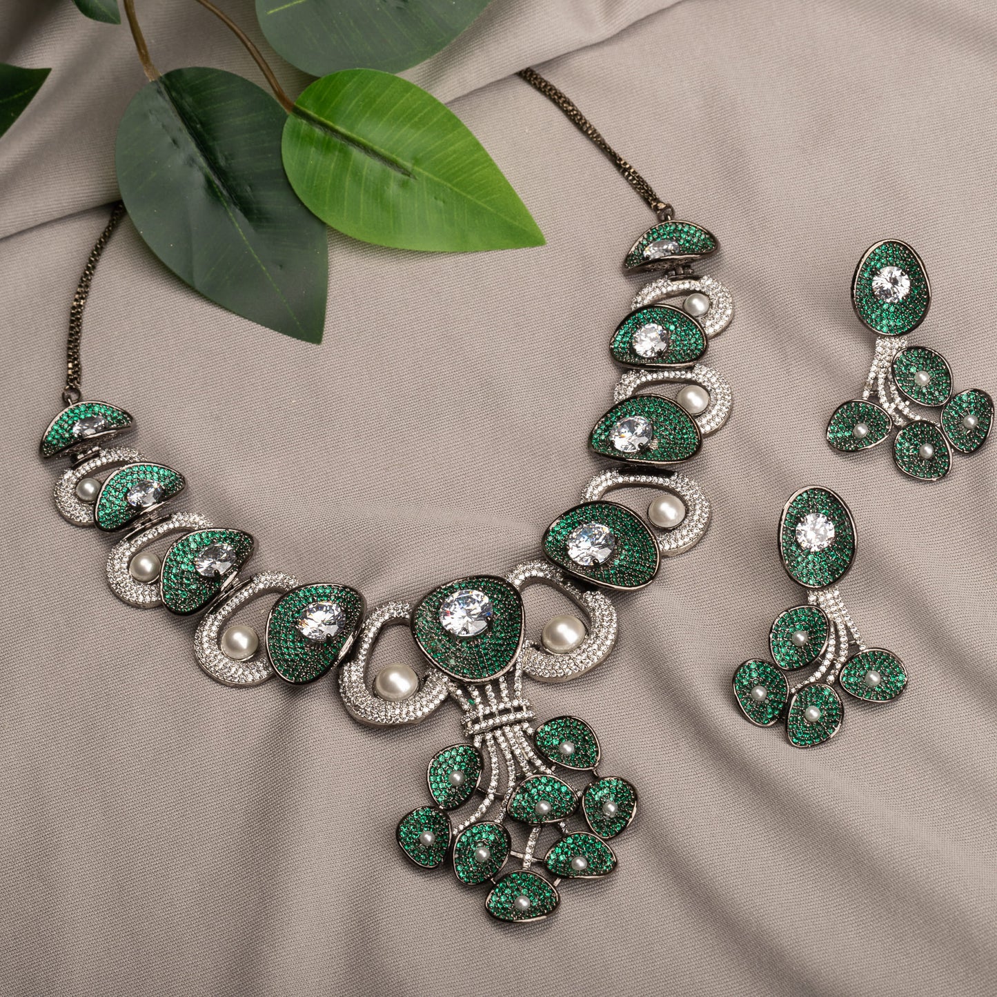 A TREE-SHAPED NECKLACE WITH GREEN AND WHITE ZIRCONS OFFERS A UNIQUE, ELEGANT CHARM.