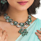 Tree-shaped necklace with green and white zircons brings a unique, elegant charm to any party look.
