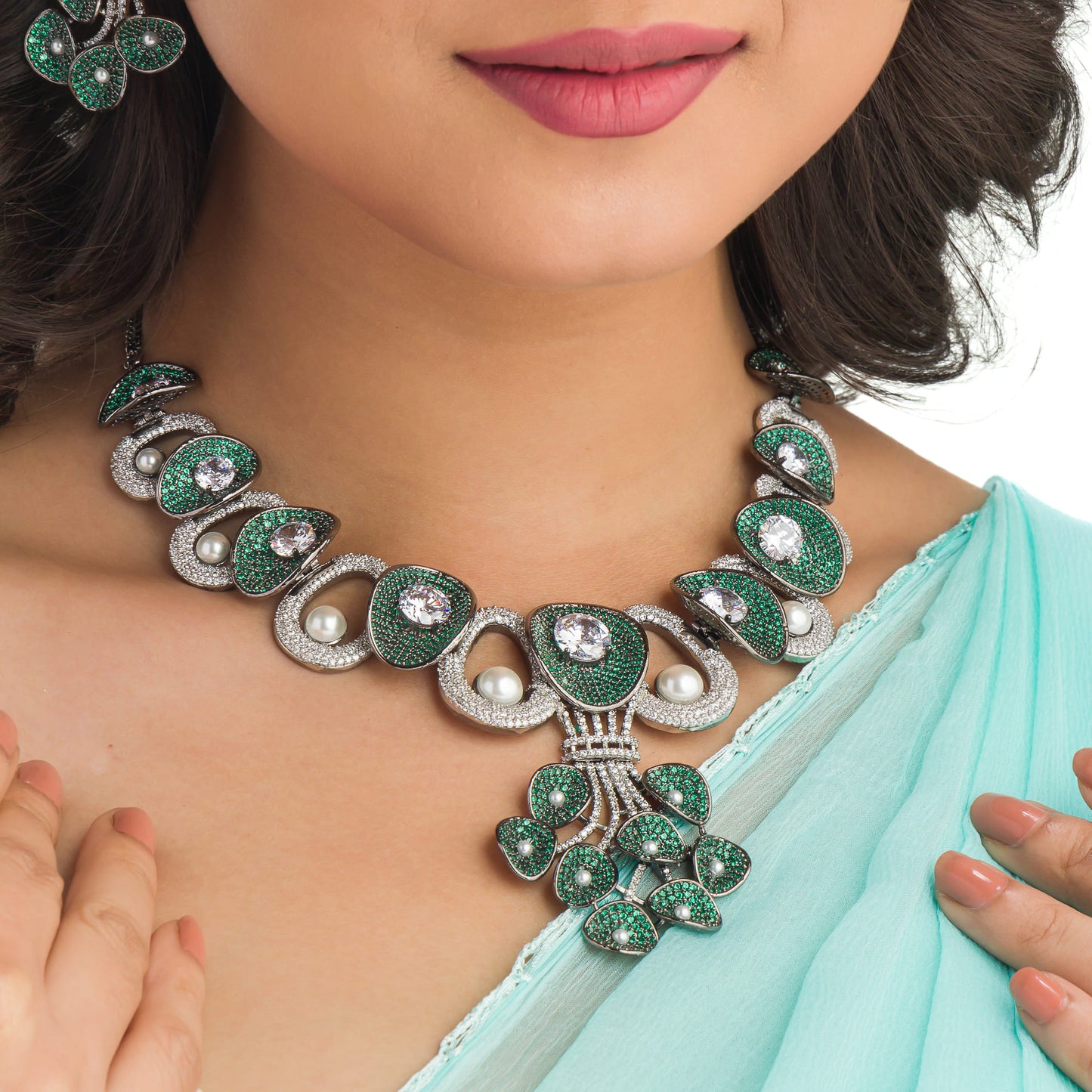 A TREE-SHAPED NECKLACE WITH GREEN AND WHITE ZIRCONS OFFERS A UNIQUE, ELEGANT CHARM.