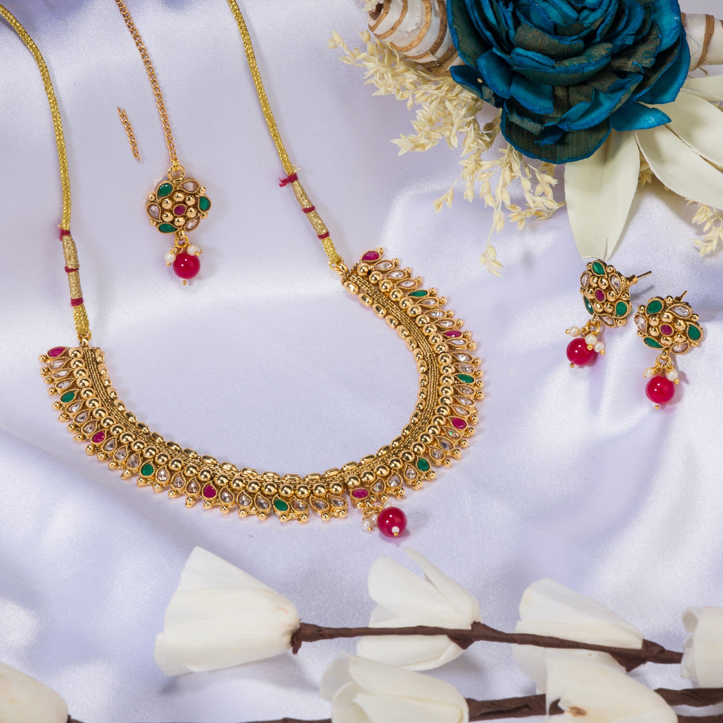 A GOLD-TONE NECKLACE WITH KUNDAN AND MAANG TIKKA OFFERS REGAL ELEGANCE.