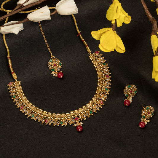 A GOLD-TONE NECKLACE WITH KUNDAN AND MAANG TIKKA OFFERS REGAL ELEGANCE.