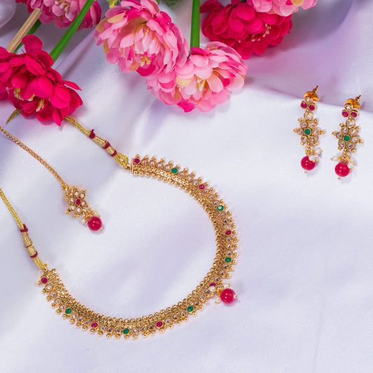 CHARMING GOLDTONE SHORT NECKLACE PAIRED WITH A MATCHING MAANG TIKA FOR A TRADITIONAL AND ELEGANT ENSEMBLE.