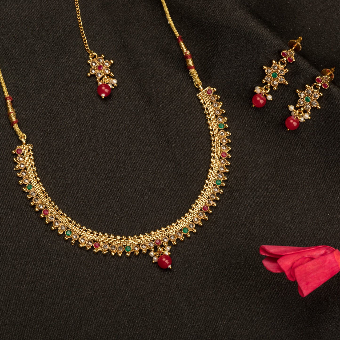 CHARMING GOLDTONE SHORT NECKLACE PAIRED WITH A MATCHING MAANG TIKA FOR A TRADITIONAL AND ELEGANT ENSEMBLE.