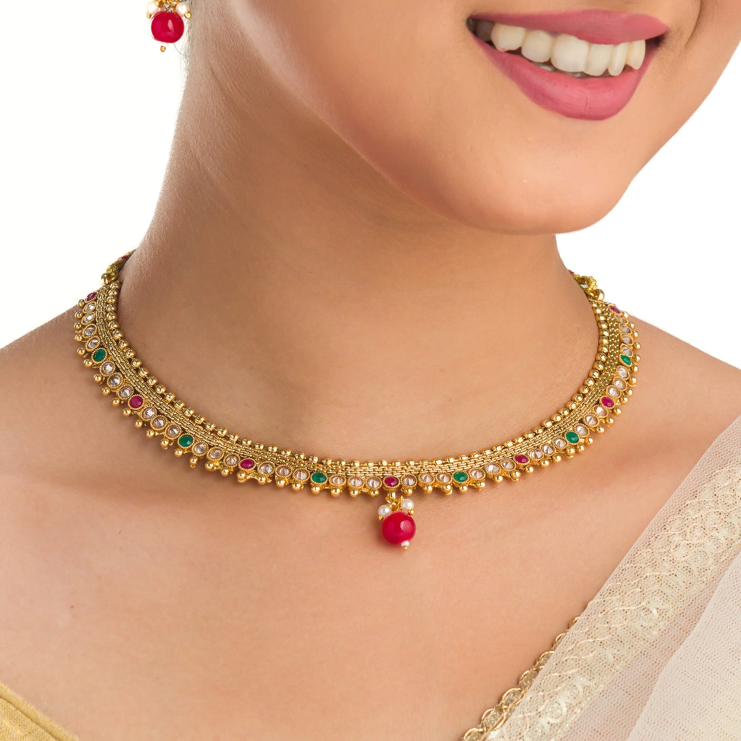 CHARMING GOLDTONE SHORT NECKLACE PAIRED WITH A MATCHING MAANG TIKA FOR A TRADITIONAL AND ELEGANT ENSEMBLE.