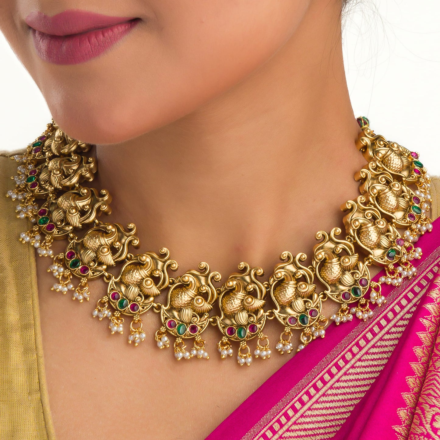 A GOLD-TONE NECKLACE WITH RED, GREEN STONES, AND WHITE PEARLS EXUDES VIBRANT ELEGANCE.