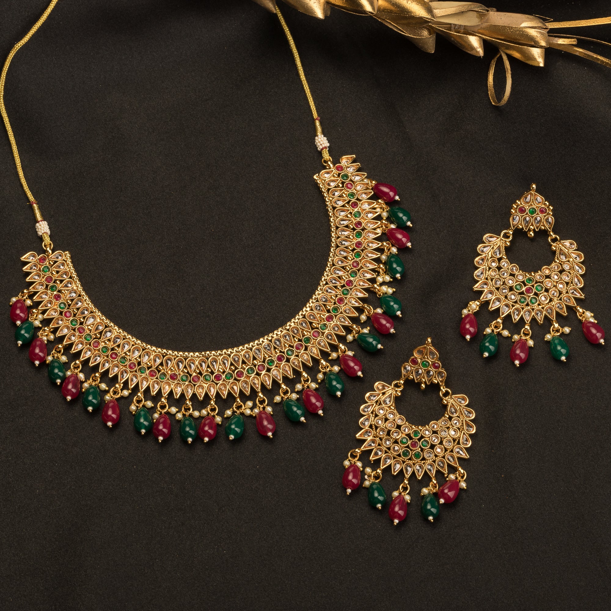 Kundan choker with maroon and green stones offers a regal and vibrant festival look.
