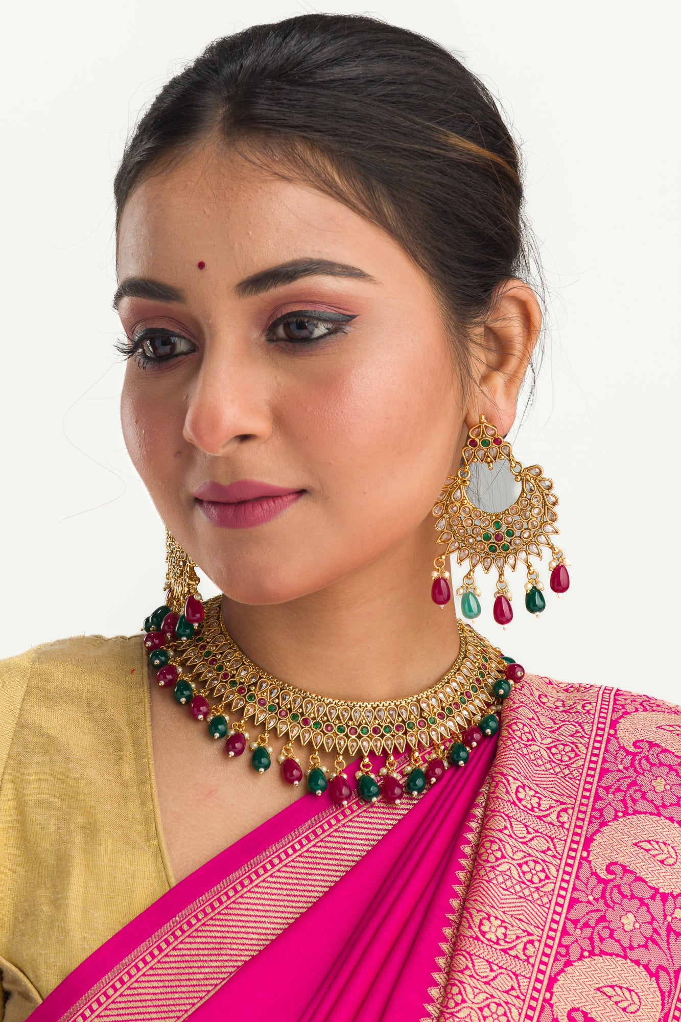 Kundan choker with maroon and green stones offers a regal and vibrant festival look.
