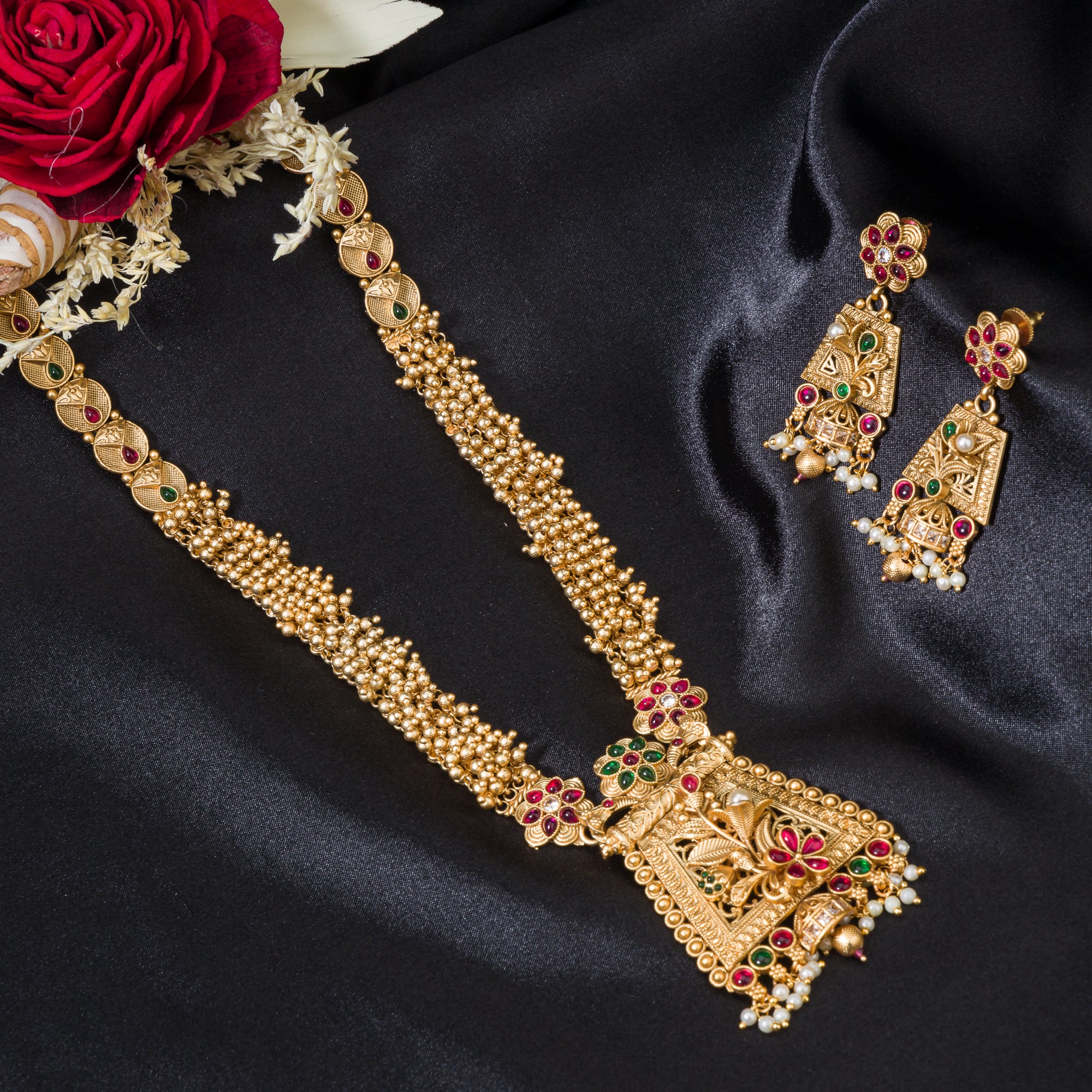 Long temple necklace with white pearls radiates timeless golden elegance for festive occasions.
