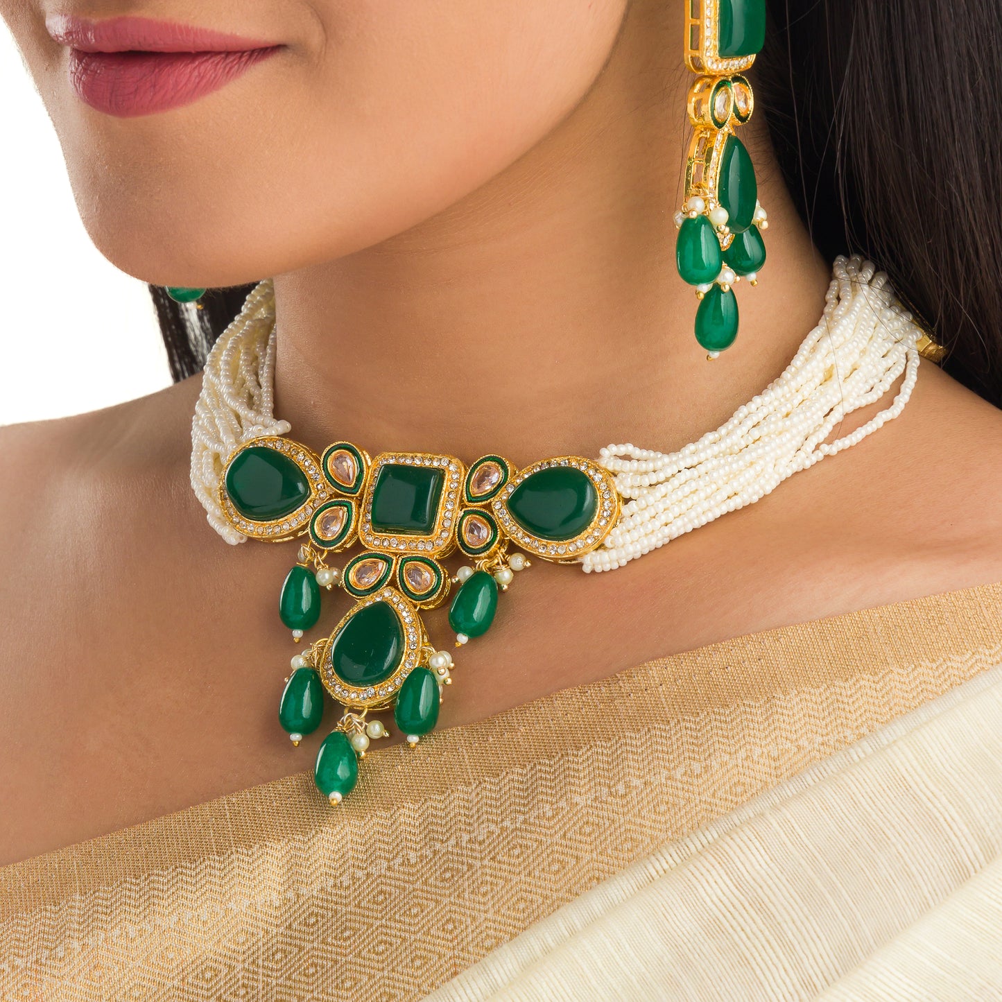 A GREEN KUNDAN AND WHITE PEARL CHOKER OFFERS ELEGANT, VIBRANT FLAIR.